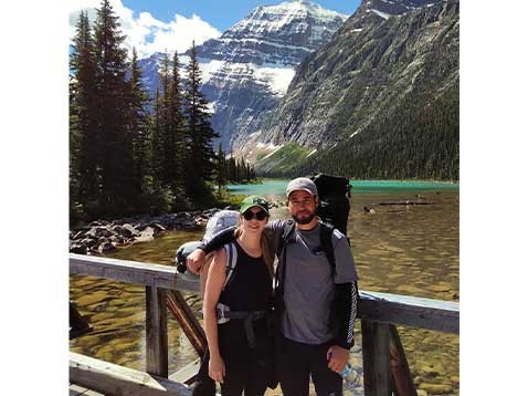 A young couple posing for a photo on a bridge over a river